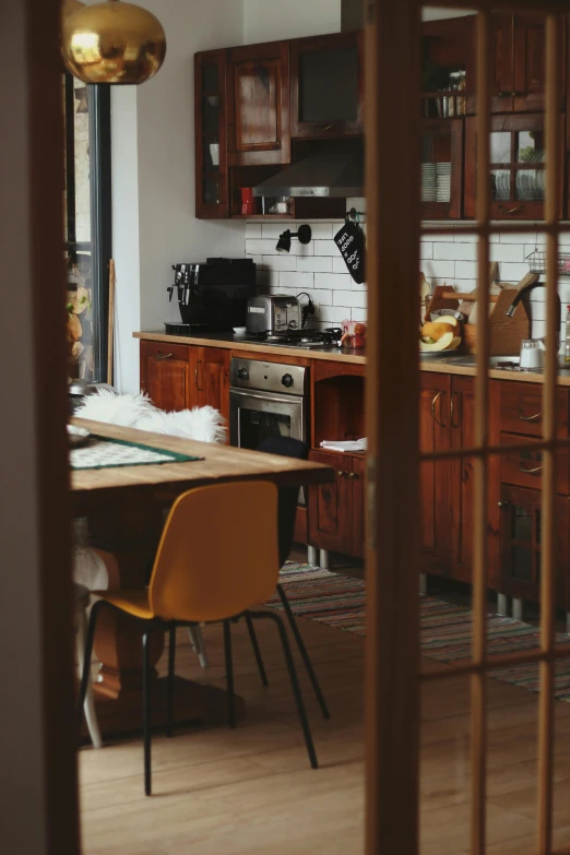 a kitchen area with wood cabinets, appliances and flooring