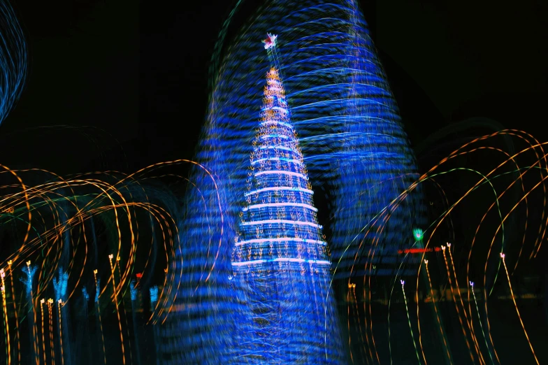 light trails and blue lights decorate a lit building