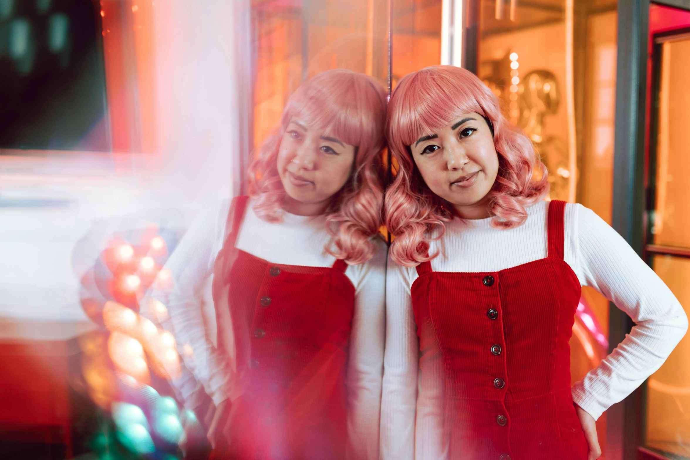 two woman are smiling in front of a mirror