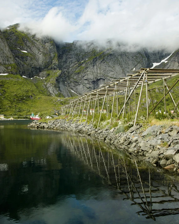 a row of wooden structures resting on the edge of a lake