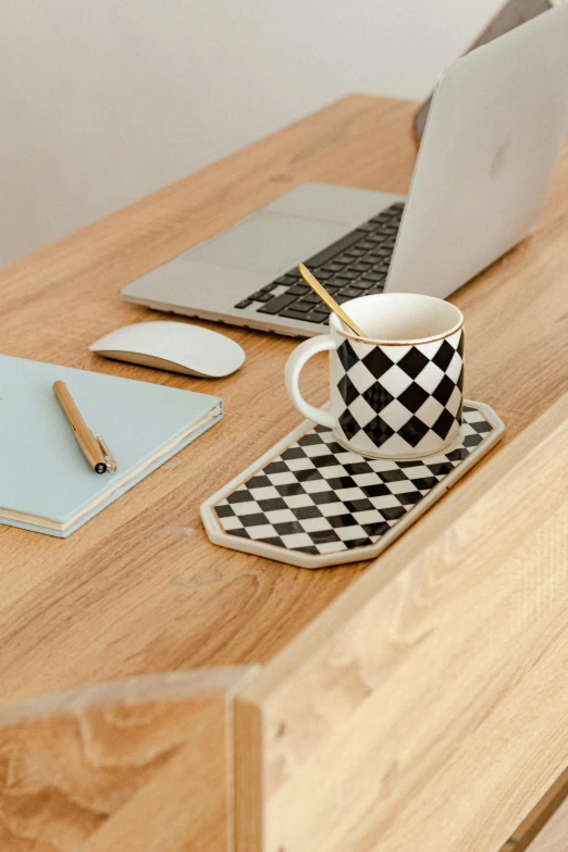 two laptops sitting on top of a wooden desk