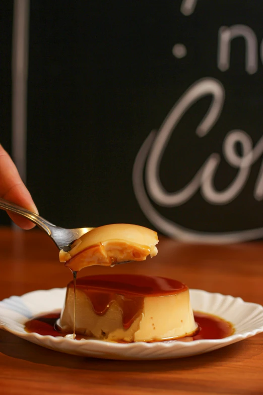 a person spreading cheese cake onto a paper plate