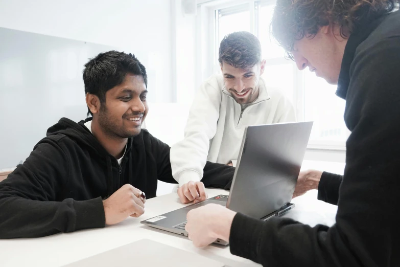 the two men are looking at the computer together