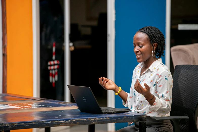 an image of a woman clapping while on her laptop