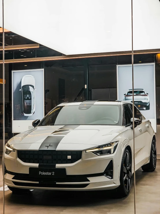 a car is reflected in the glass walls of a vehicle showroom