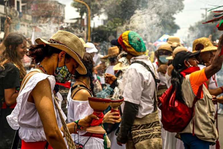 many people standing around with hats and a cigarette