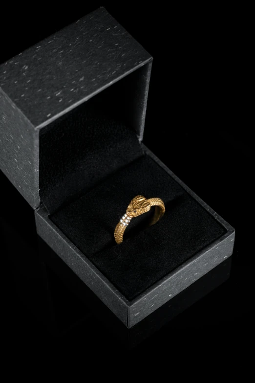 a gold ring inside of an opened box