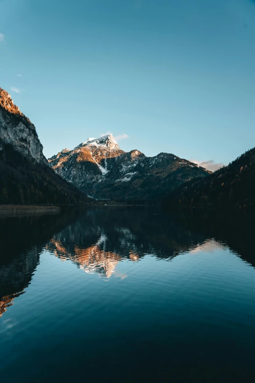 a lake sits in front of mountains covered in snow