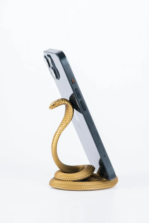 a black and white cell phone with a gold snake on top