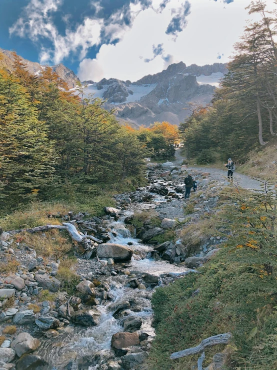 two people trekking down a mountain path