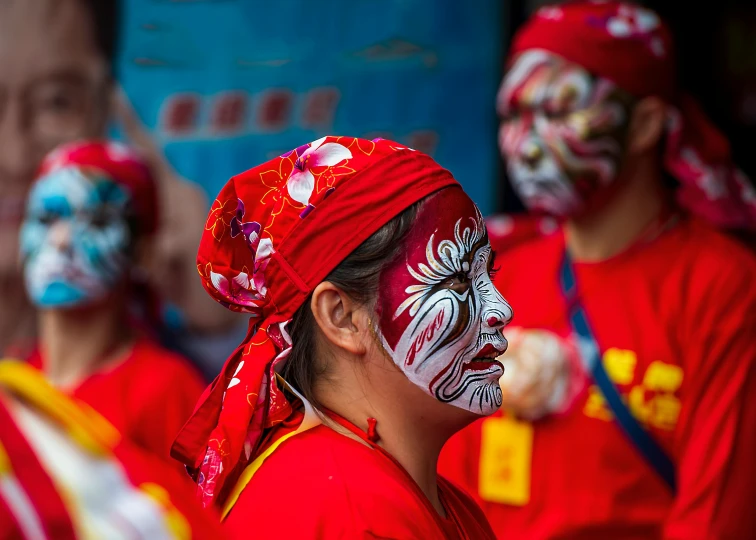 group of people with painted faces all wearing costumes