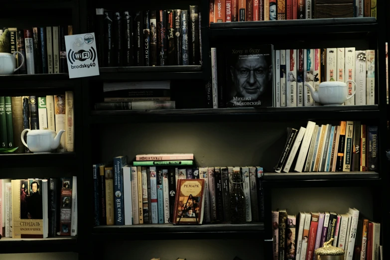 a large shelf full of books, tea and a cup