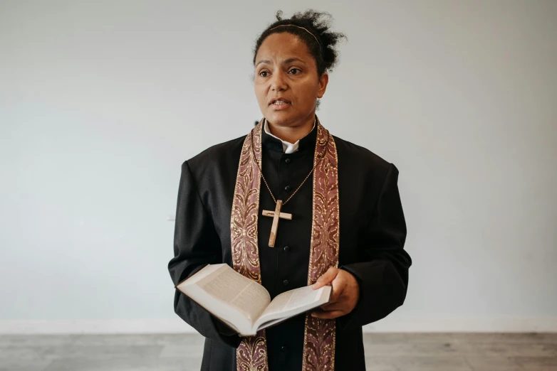 a woman dressed in a priest's outfit holding a book