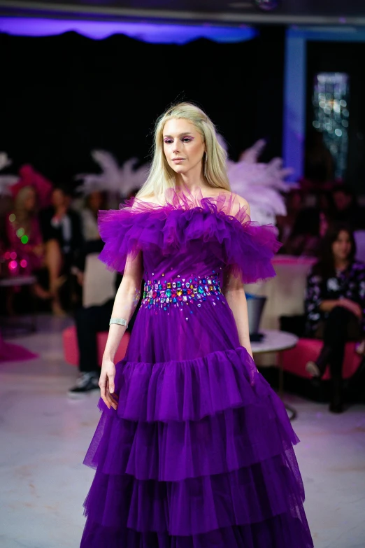 the model is dressed in purple, tiered dress