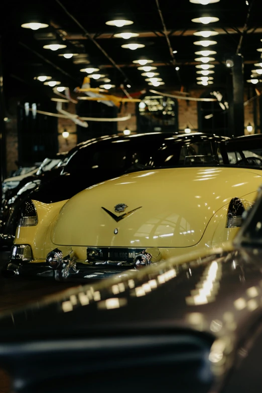 yellow vw bug in the garage next to black vw bug