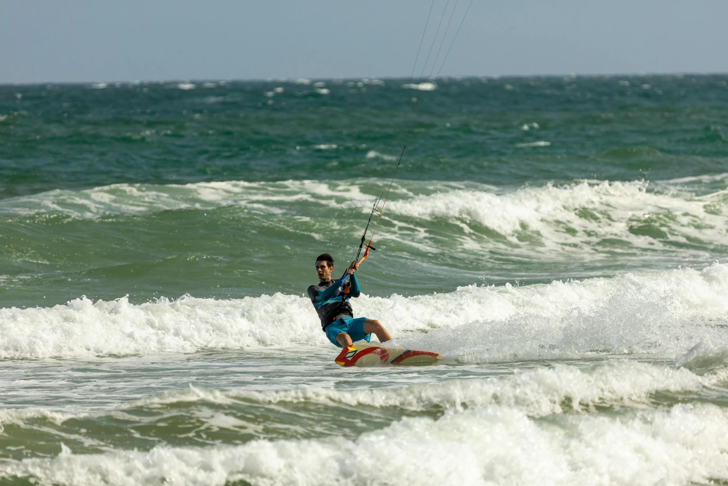 a man in blue is wind surfing in the water