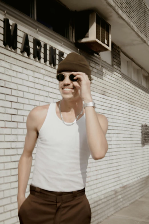 a man in sunglasses walks by a building