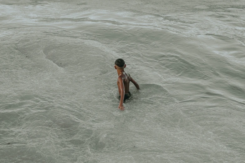 a girl is floating alone on her back in the ocean