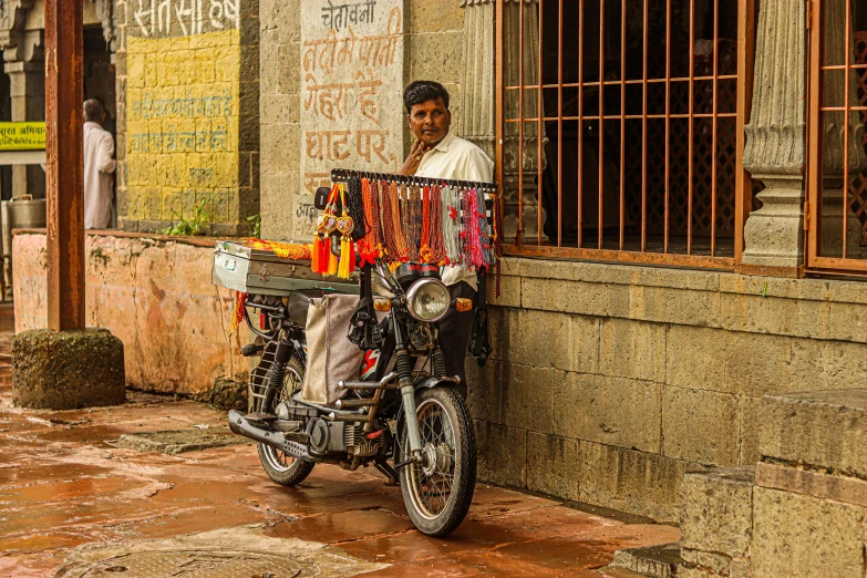 man standing beside motorcycle parked in front of building