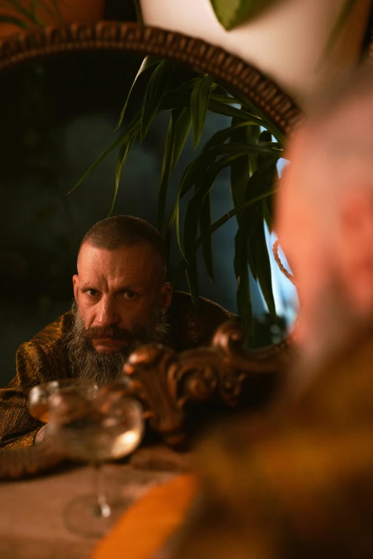 a man is sitting in front of a mirror with a beard