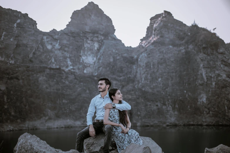 a couple of people that are sitting on some rocks