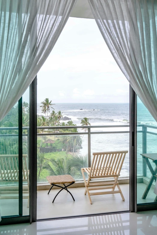 a bench sitting by an open window overlooking the ocean