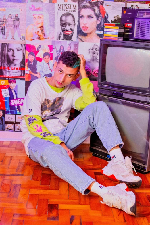 a young man sitting on the floor in front of an old television