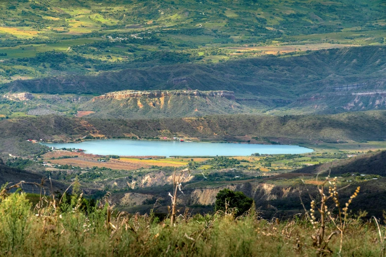 a field with a blue lake and lots of green