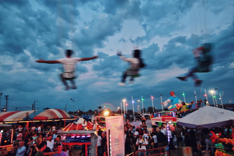 two skateboarders doing tricks in front of a crowd