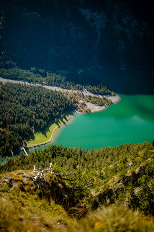 a beautiful green lake sits in the middle of a mountainous area