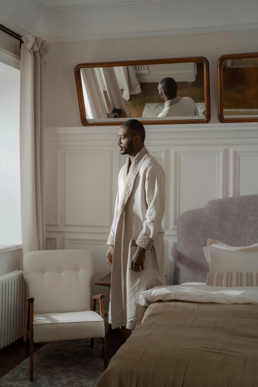 a man standing in a bed room near a window