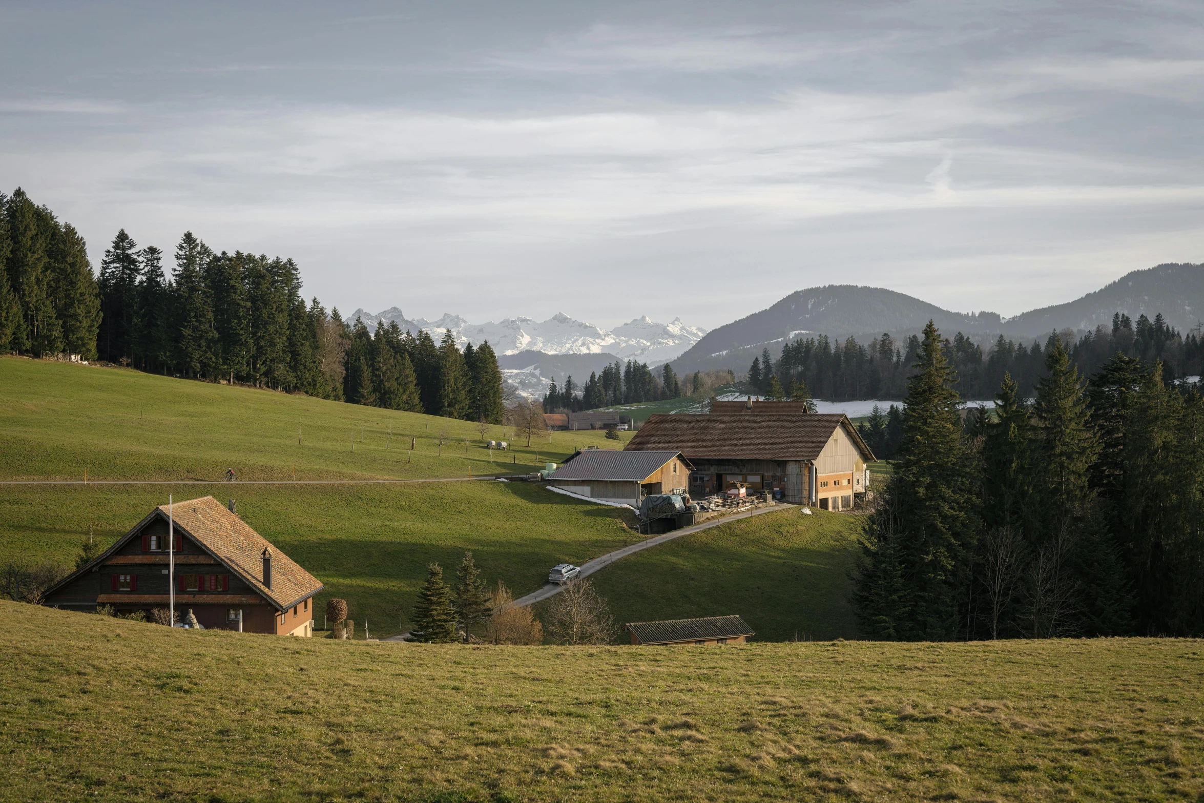 a large house on a hillside near mountains