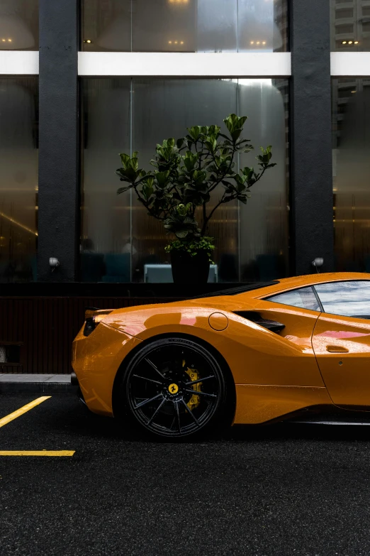 a sleek orange sports car parked in front of a large building