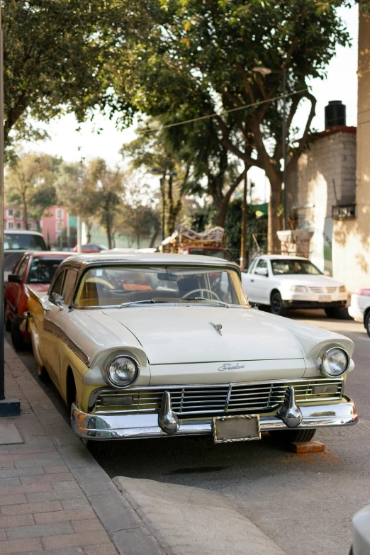 a vintage car sitting out in a parking lot on a city street