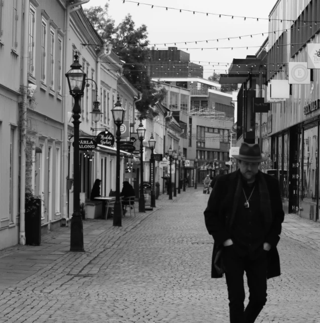 a man is walking down a small brick alley