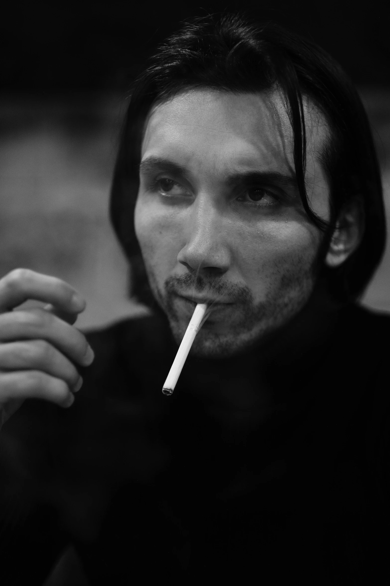 a black and white po of a man with long hair smoking