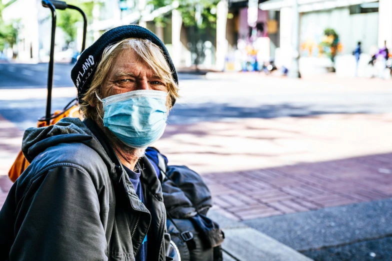 a man wearing a surgical mask on his face walking down the street