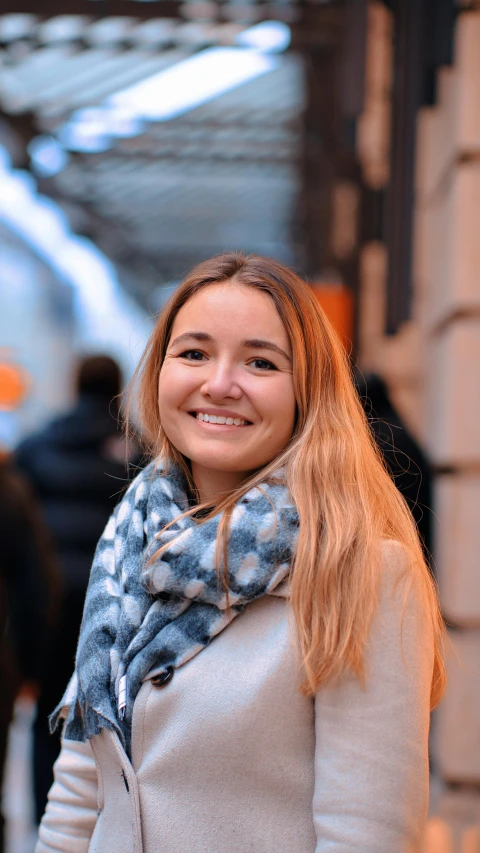 a woman smiling for the camera near a building