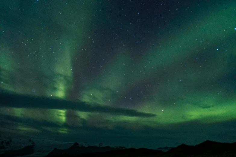 the aurora is glowing brightly over a snowy landscape