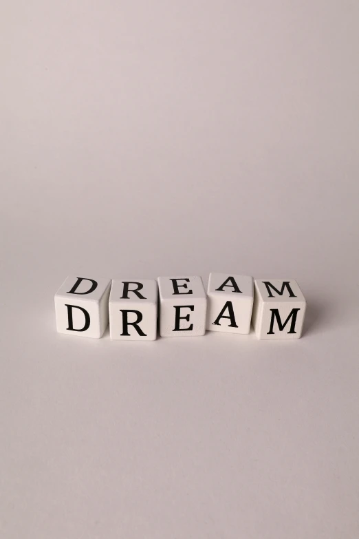 block letters spelling dream, dream, dream and dream on a white surface