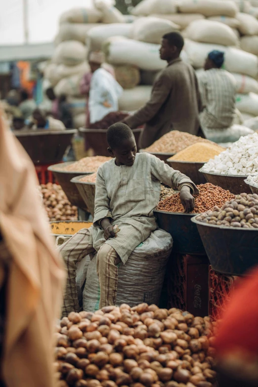 many men stand at a market filled with peanuts