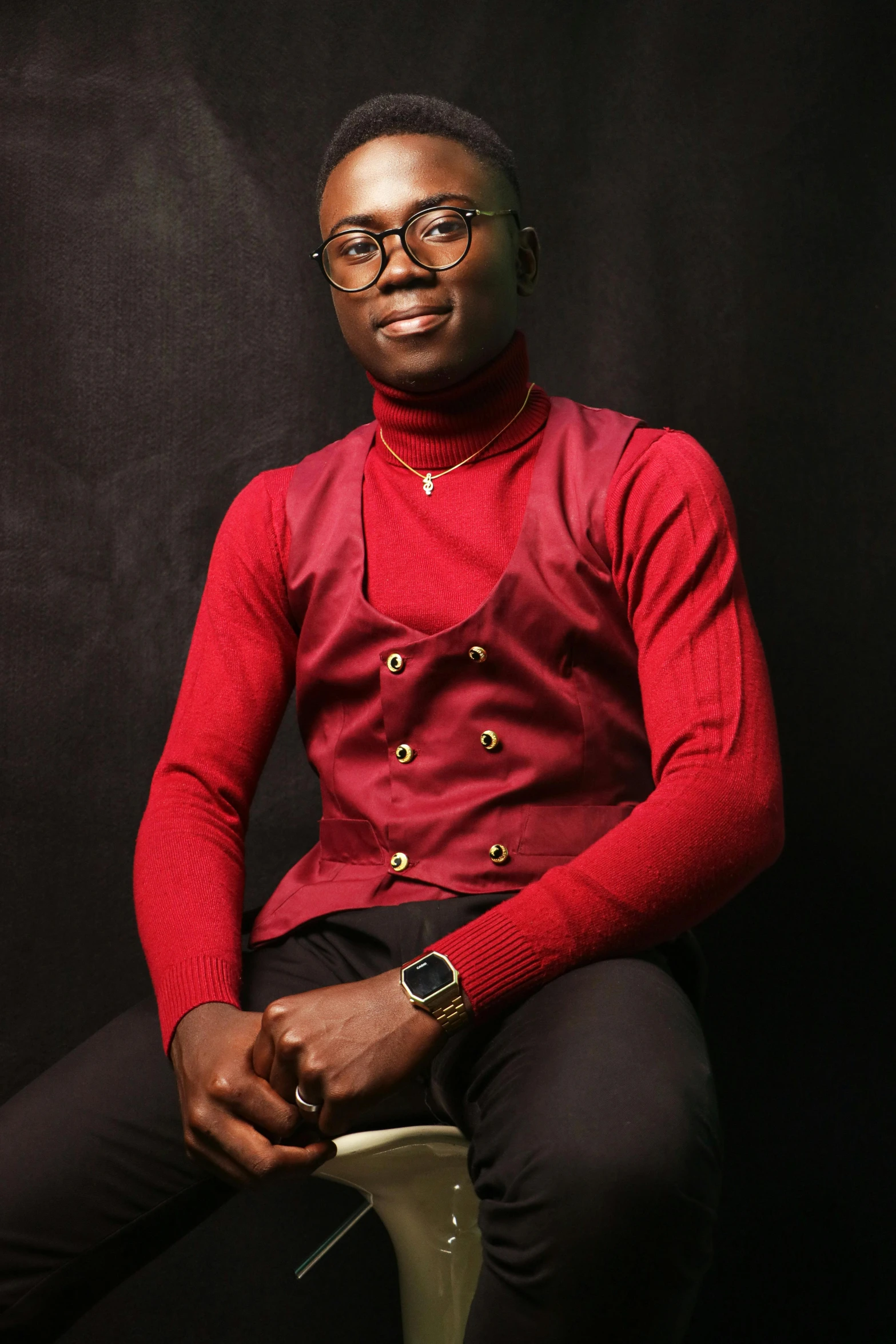 an african american man wearing glasses and a red shirt is seated