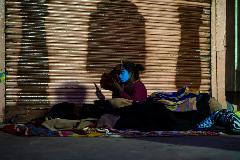 a person sitting on the street next to a building