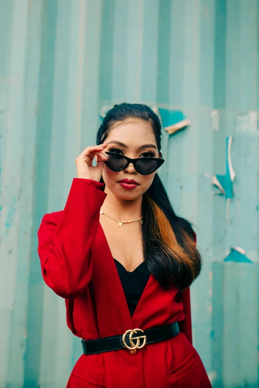 a young woman wearing a red suit and black sunglasses