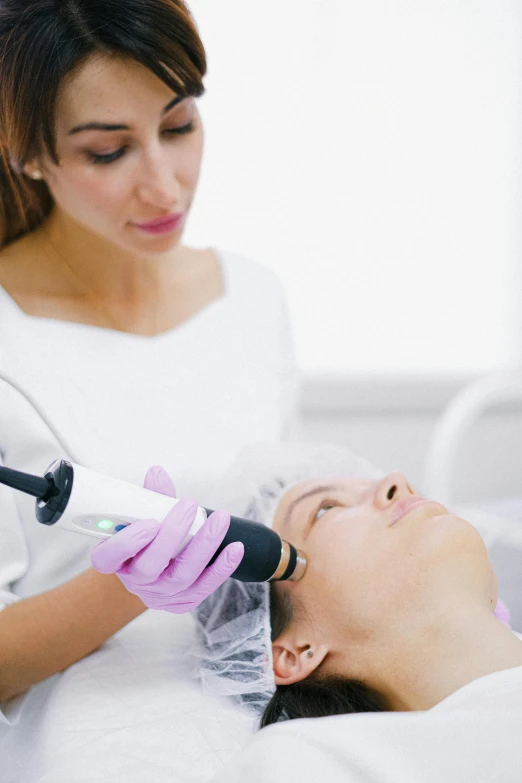 a woman getting botula treatment on another woman's face