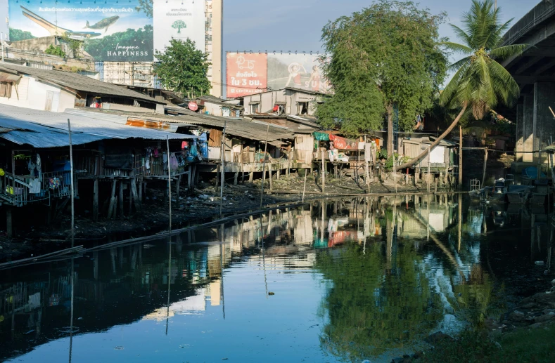 a river runs through a town with wooden houses, and other stores