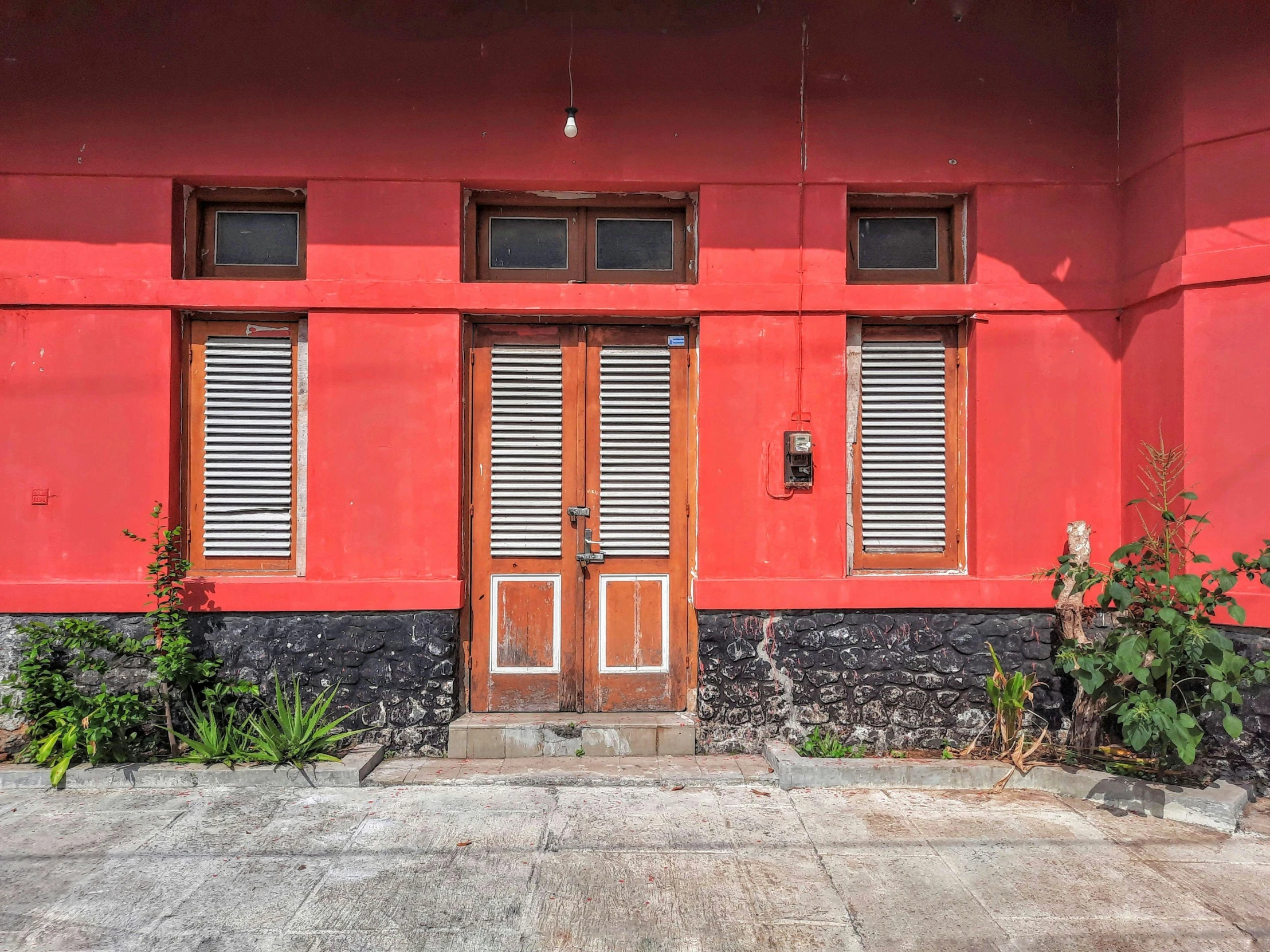 a red building with three shutters that are open