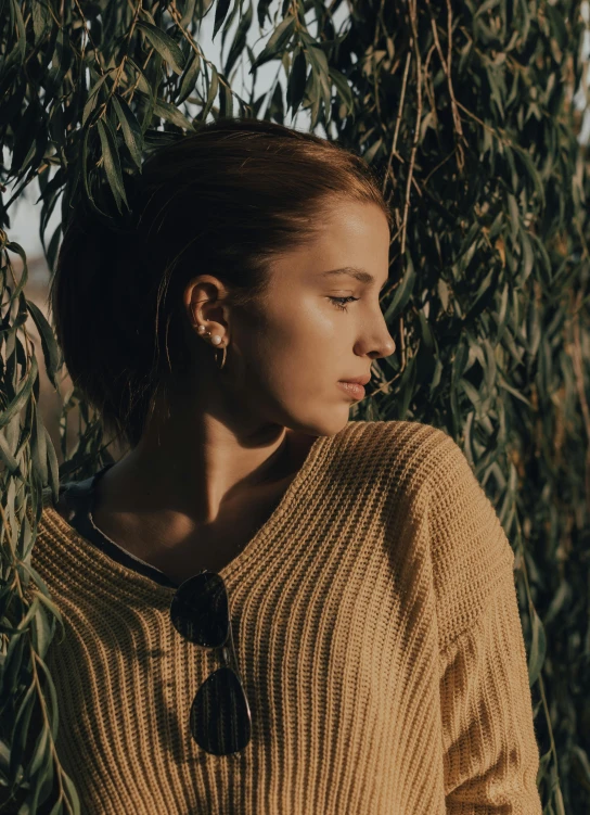 a woman wearing a sweater standing underneath some nches