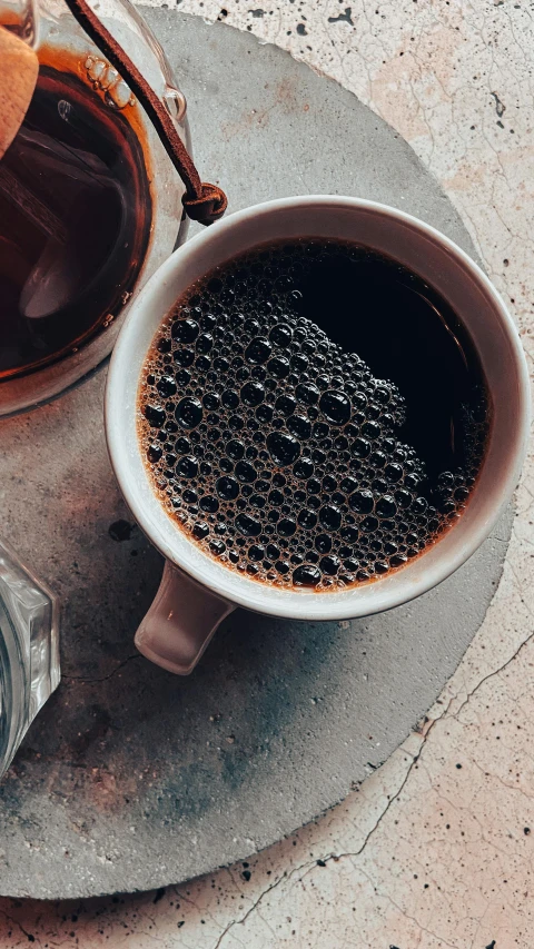 a cup of coffee and some kind of spoon on a table