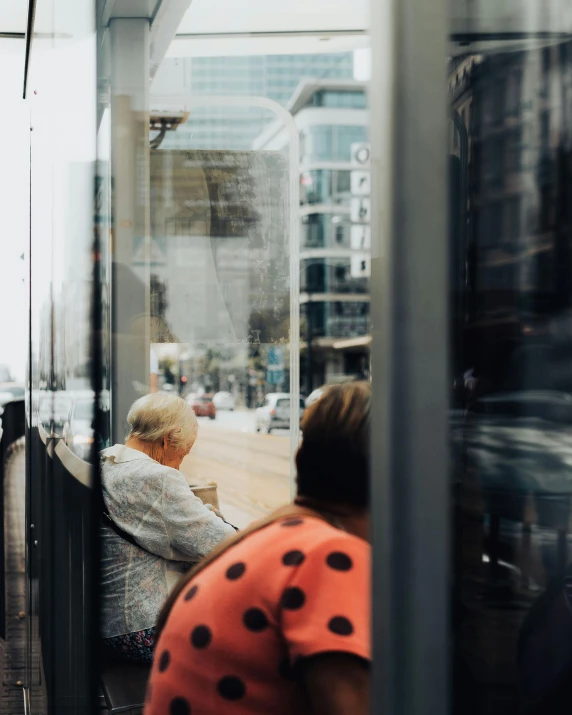 some people sitting on a bench looking out the window